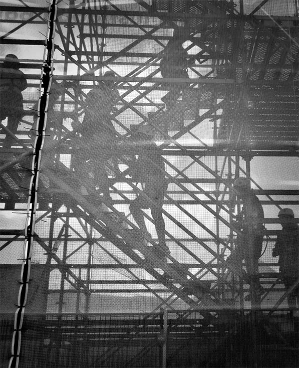 Workers climbing up scaffolding