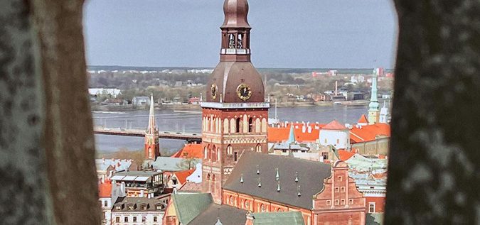 A wide shot of a clock tower in Latvia.