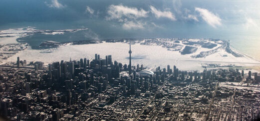 A picture of Toronto taken from the inside of a plane representing Canadians looking for the cheapest real estate outside Canada